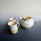 Ceramic teapot and two mugs with english country side designs in a semi gloss opague glaze.